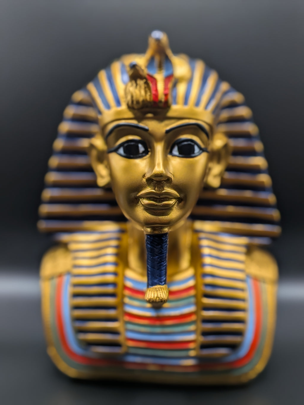 King Tutankhamun Egyptian pharaoh bust showing gold nemes headdress and uraeus cobra detail