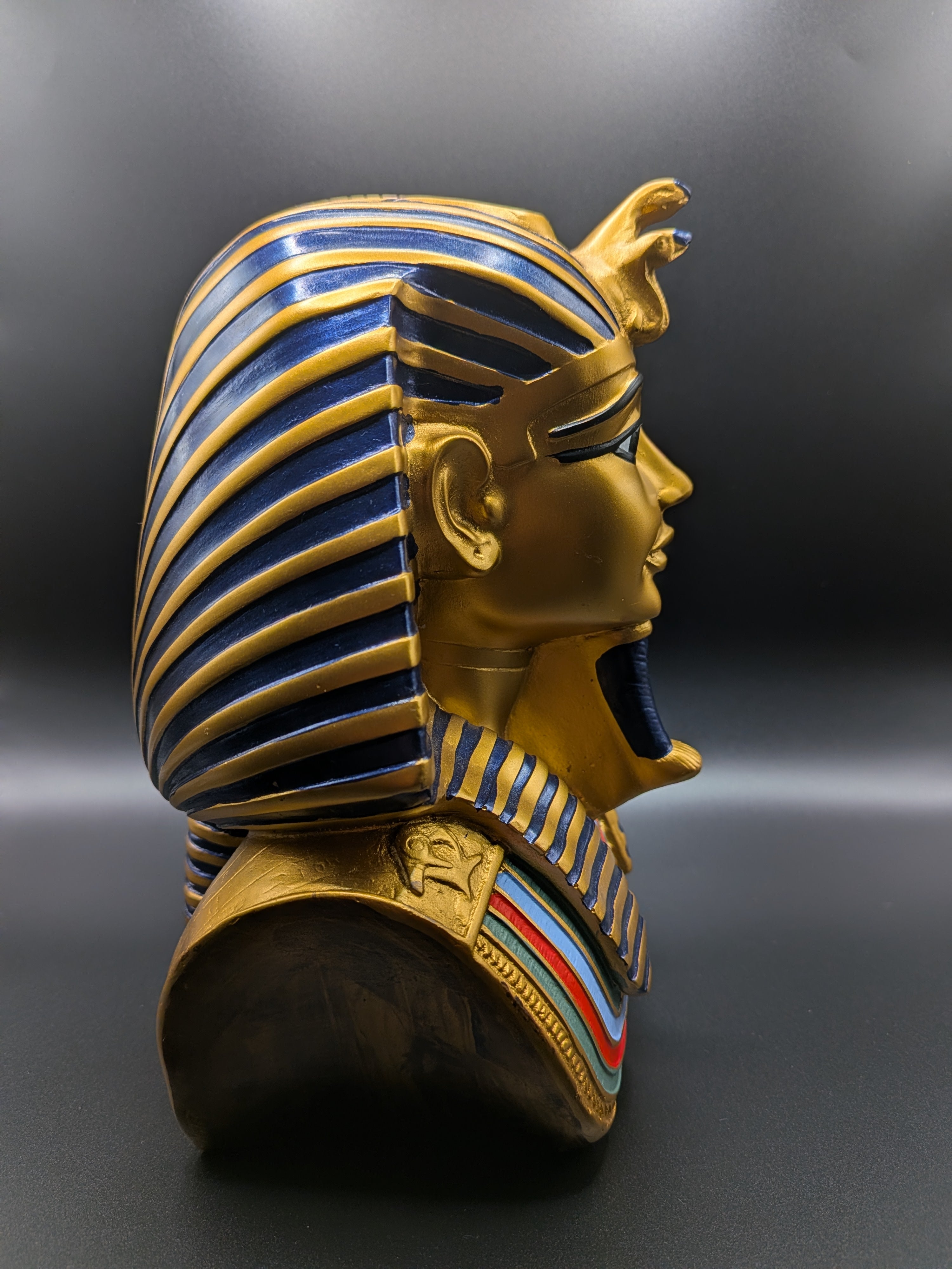King Tutankhamun figurine side view showing striped headdress and decorative collar